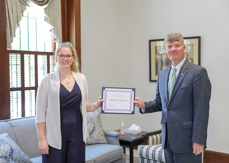 Raymond M. Thompson, President and CEO of Taylor Bank, presenting scholarship certificates to Madison Johnson.