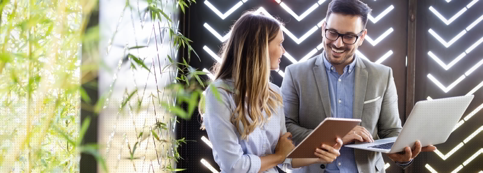 Two business people holding laptops