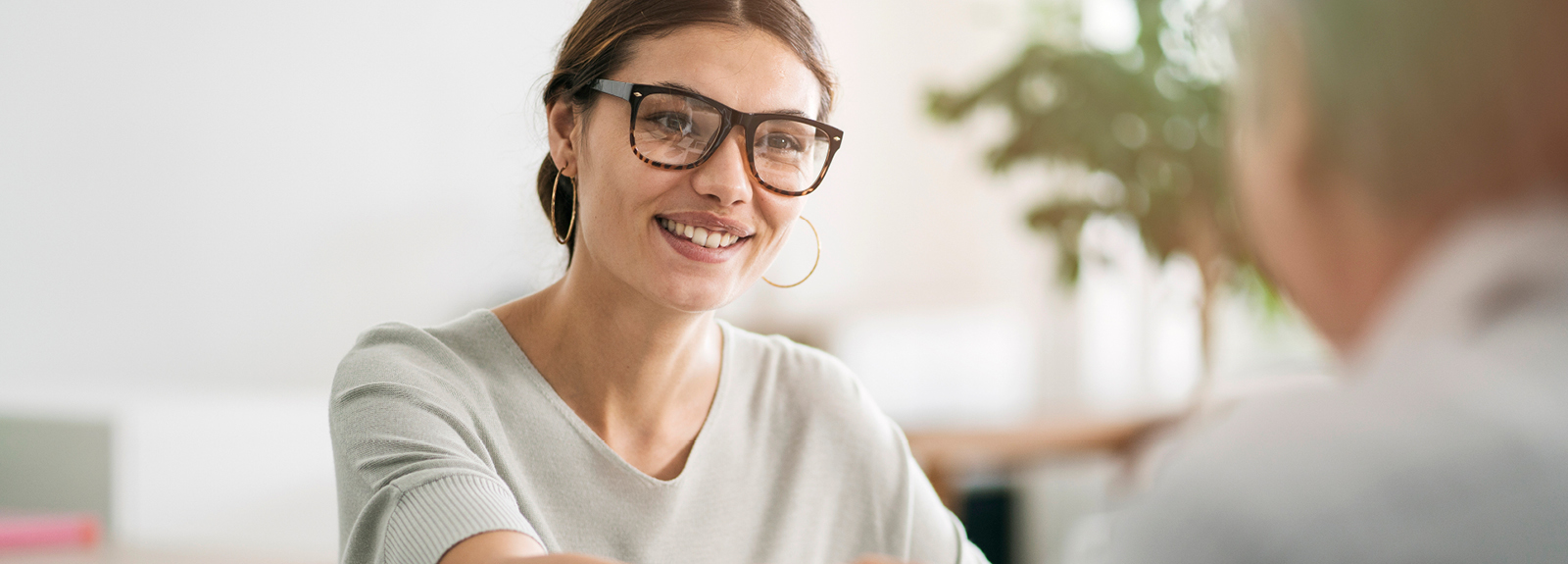 Smiling woman shaking hands during business meeting.