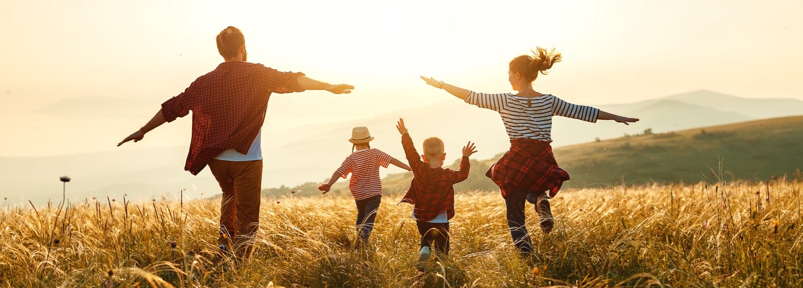 Young family running through a field