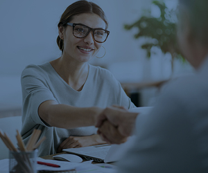 Smiling woman shaking hands during business meeting.
