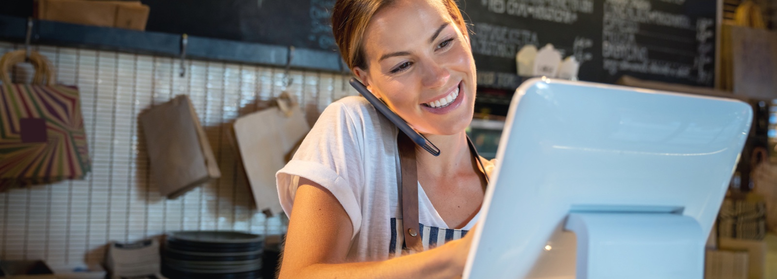 A cafe worker entering orders on a screen