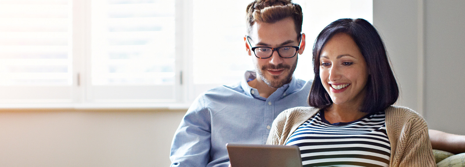 Couple searching the web on a tablet device.