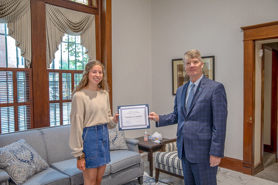 Raymond M. Thompson, President and CEO of Taylor Bank, presenting scholarship certificates to Caroline Gardner at the Bank’s Main Office in Berlin